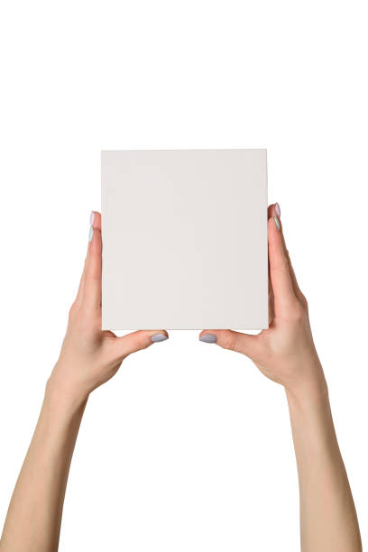 istock Small white cardboard box in female hands. Top view. Isolate 1135587930