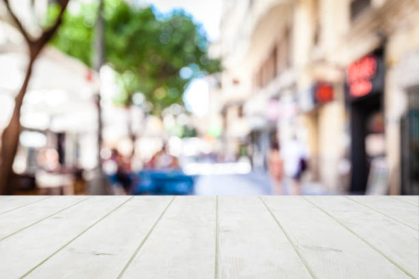 istock Empty wooden table with defocused sidewalk cafe at background 1135589652