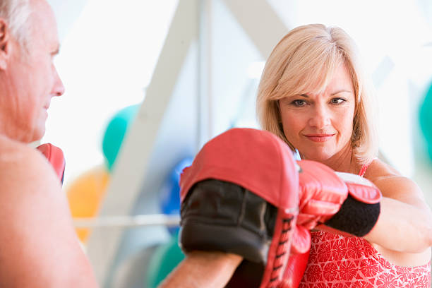 Woman Boxing With Personal Trainer At Gym  boxercise stock pictures, royalty-free photos & images