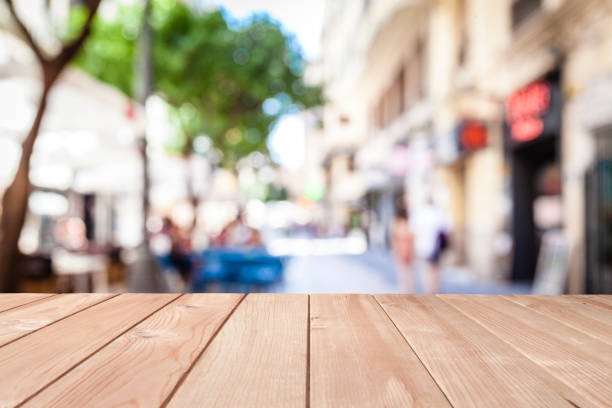 istock Empty wooden table with defocused sidewalk cafe at background 1135592682