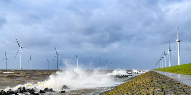 istock Wind turbines in an offshore wind park during a storm with big waves hitting the shore 1135593967