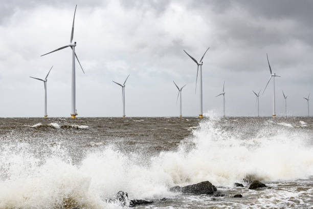 istock Wind turbines in an offshore wind park during a storm with big waves hitting the shore 1135593998