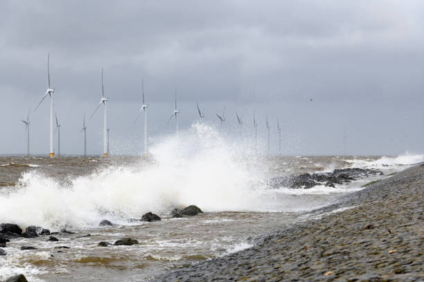 istock Wind turbines in an offshore wind park during a storm with big waves hitting the shore 1135594033