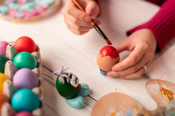 istock Women hands decorating and painting easter eggs 1135596431