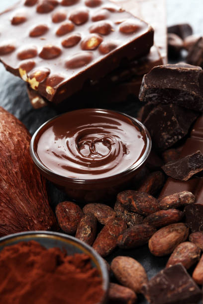 istock Melting chocolate or melted chocolate with a chocolate swirl and stack, chips and powder on black 1135599381