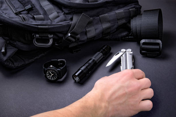 Everyday carry (EDC) items for men in black color - backpack, tactical belt, flashlight,  watch and silver multi tool.