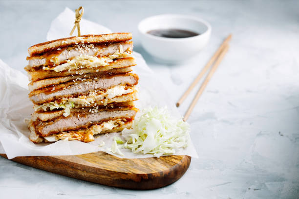 katsu sando-traditionelles japanisches cutlet-sandwich mit frittiertem schweinefleisch, kohl, japanischer mayonnaise und tonkatsu-sauce auf heller kulisse in der nähe mit kopierplatz für text. japanisches fast food - tonkatsu stock-fotos und bilder