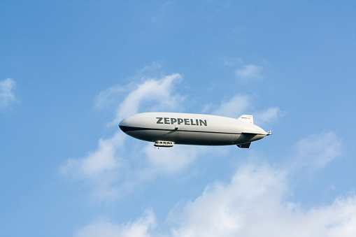 Lake of Constance, Germany - May 22, 2010:: Airship, zeppelin flying in the blue sky with white clouds. Zeppllin airships often offer tourist passagers for leisure flights.