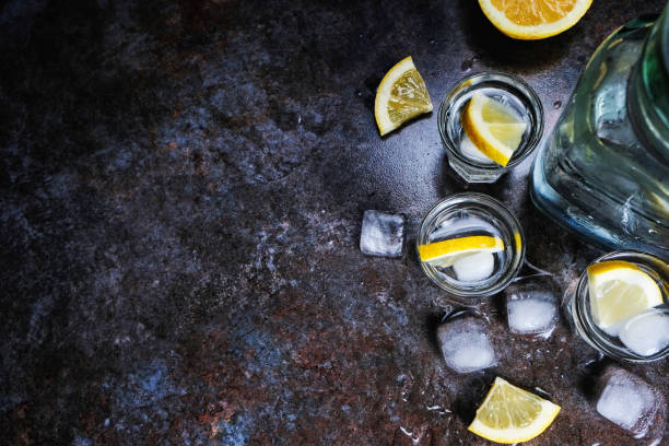 istock Tequila vodka shots and bottle with lemon slices, top view 1135608987