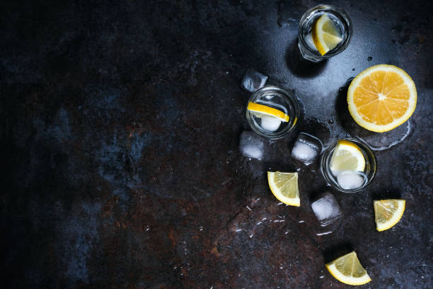 istock Vodka in glasses with lemon and ice. On the black stone table. Copyspace. 1135608995