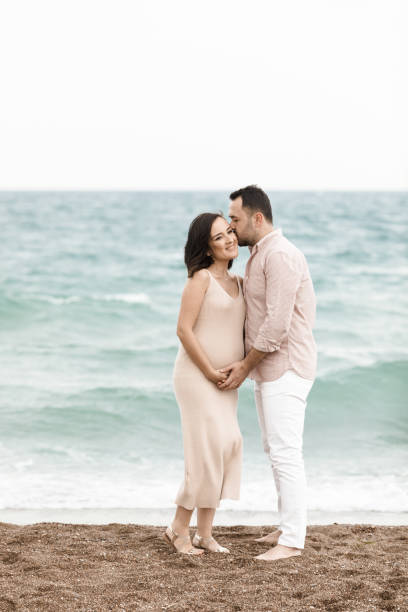 istock Handsome man touching his pregnant wifes belly 1135609464