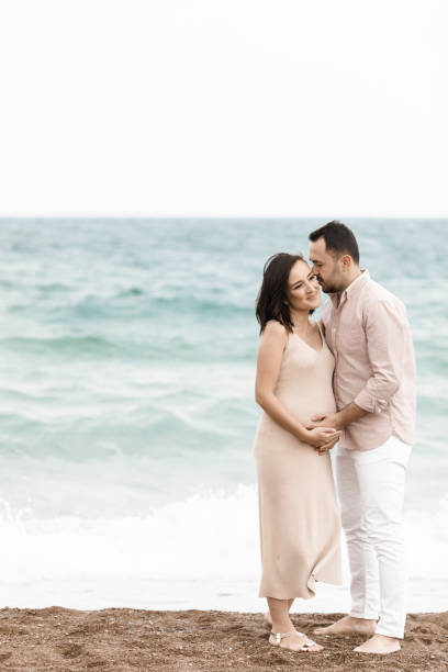 istock Handsome man touching his pregnant wifes belly 1135610219