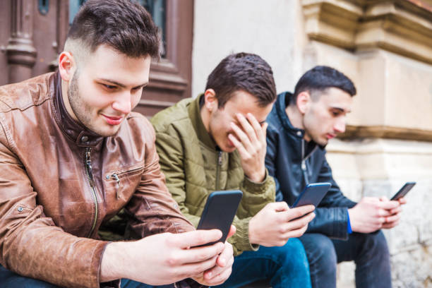 istock Three friends holding their smart phones 1135612158