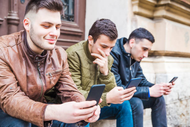 istock Three friends holding their smart phones 1135612328