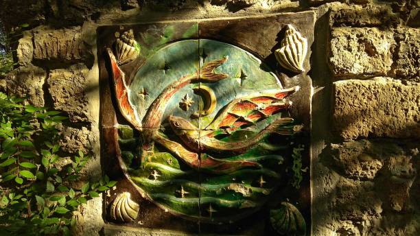 istock Fish & seashells ceramic decorative bas-relief tile on a stone wall, imitating an ancient Greece wall. 1135612850