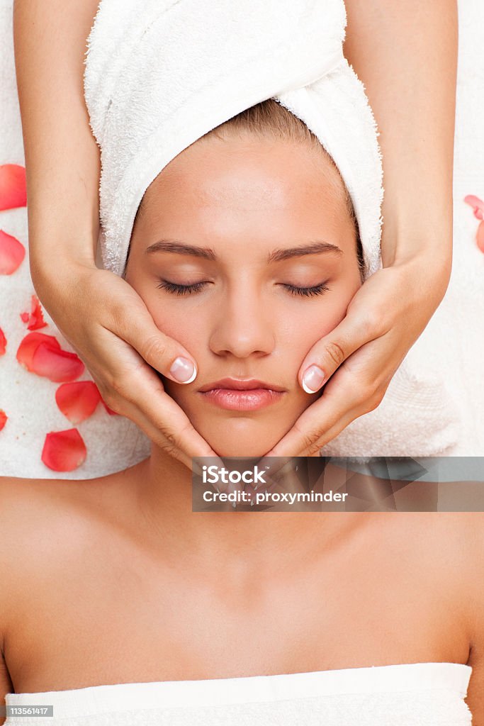 Bela jovem mulher recebendo massagem de rosto de mulher mãos - Foto de stock de Massagem Facial royalty-free