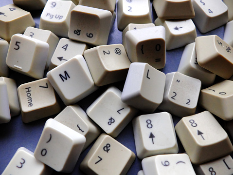 White computer keyboard keys, mostly numeric with ML (Machine learning) buttons at the front. Concept of unstructured big data that need to be sorted ready to be consumed by ML or deep learning.