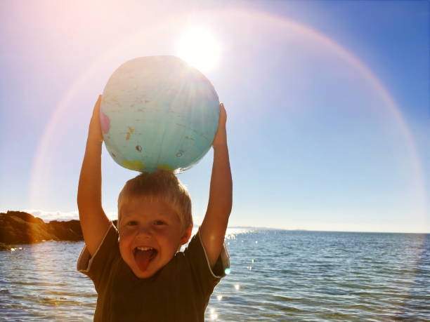 istock Child Plays with Globe Ball by Sea 1135616301