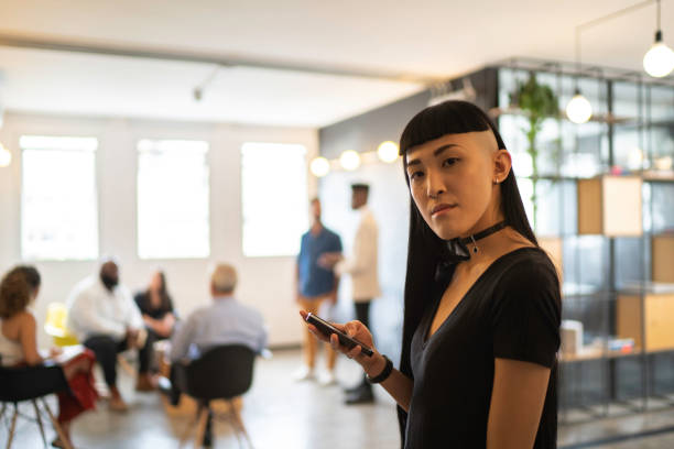 istock Young businesswoman using smartphone at modern company 1135620822