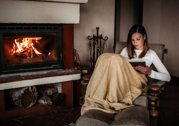 istock Woman relaxing near fireplace 1135636849