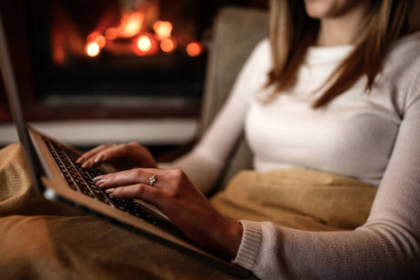 istock Woman using laptop near fireplace 1135637407