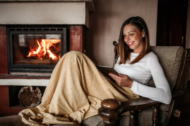 istock Woman relaxing near fireplace 1135637477