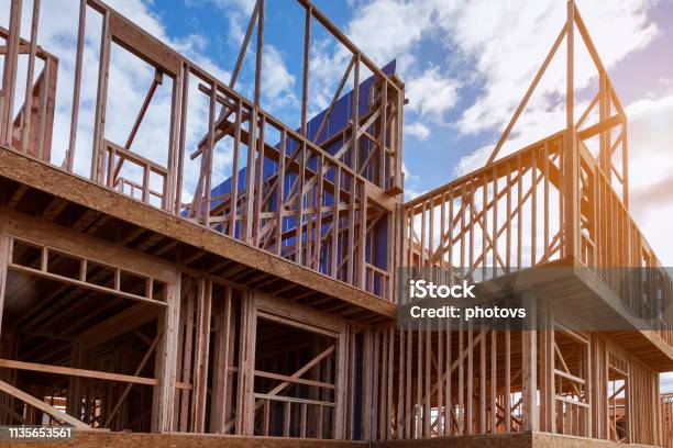 New House Under Construction Framing Against A Blue Sky Stock Photo - Download Image Now