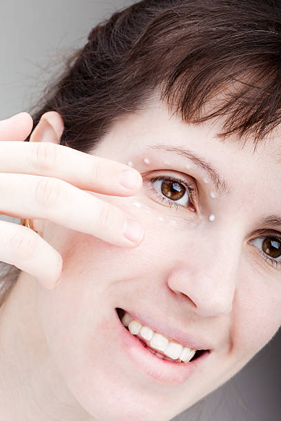 istock Women applying eye skin cream 113565360