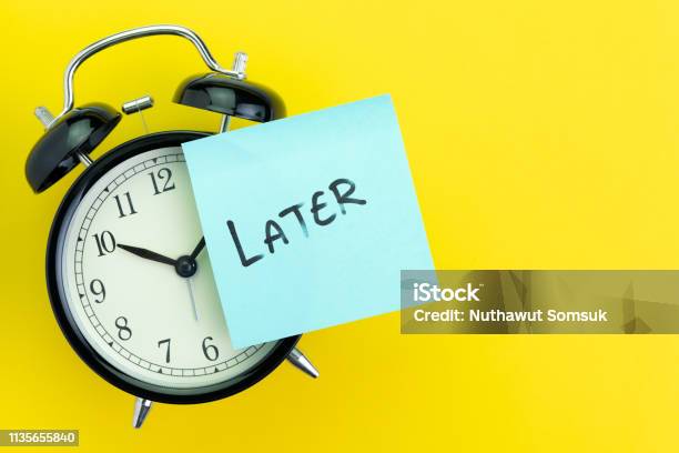 Sticky Post With Handwriting The Word Later Stick On Alarm Clock On Solid Yellow Background With Copy Space Using As Procrastination Self Discipline Or Laziness Concept Stock Photo - Download Image Now