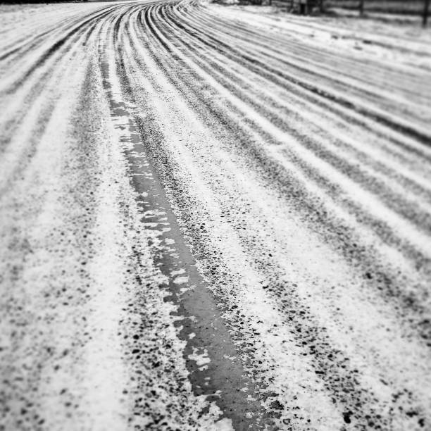 Tire tracks in the snow on a paved road stock photo