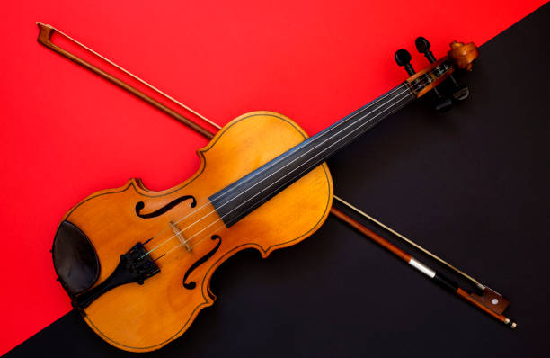 istock Violin and bow on a red and black background 1135658781