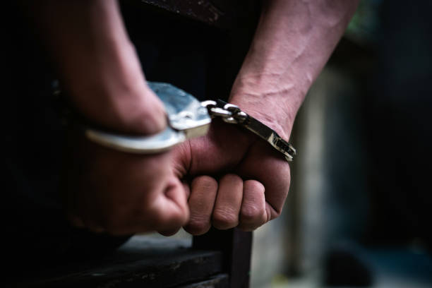 Man on the chair in Handcuffs. Rear view and Closeup Man on the chair in Handcuffs. Rear view and Closeup ,Men criminal in handcuffs arrested for crimes. With hands in back,boy  prison shackle in the jail violence concept. arrest photos stock pictures, royalty-free photos & images