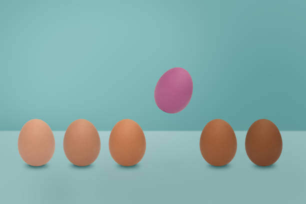 istock Flying pink egg and  different shades color of eggs on blue background. Minimal Easter idea. 1135662411