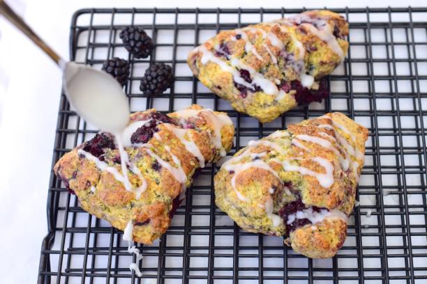 istock Blackberry lime scones on cooling rack pouring with glaze sugar 1135669791
