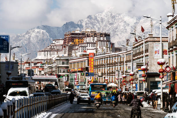 tráfico en el casco antiguo de lhasa con el palacio de potala - tibetan buddhism fotos fotografías e imágenes de stock