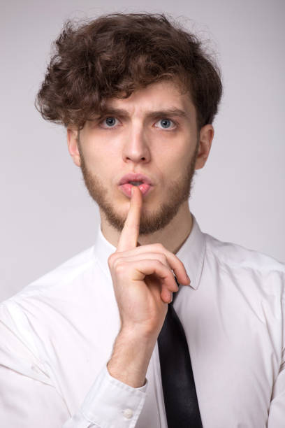 istock Serious young beard man keeps finger on lips, want to be conspiracy or make silence 1135679301