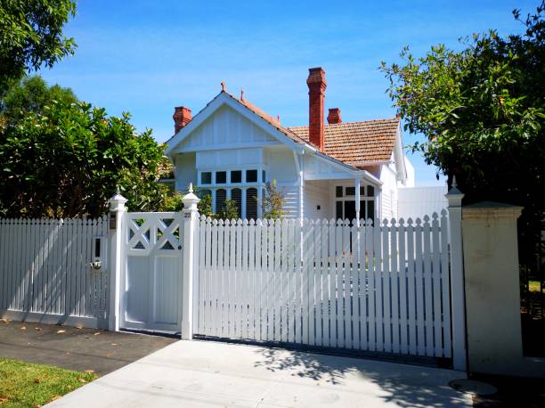 Traditionally built Australian bungalow - Melbourne Melbourne, Australia: March 14, 2019: Rustic traditional bungalow with a white picket fence in a Melbourne suburb with red roof tiles and off road parking. traditionally australian stock pictures, royalty-free photos & images