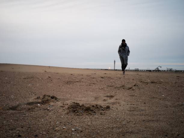 istock lonely woman on an empty beach in winter 1135684072
