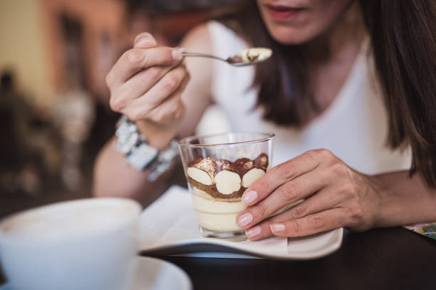 Young women tourist discovering Italy, enjoying coffee and tiramisu cake in Verona-Italy