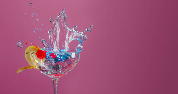 istock Cocktail in glass with splashes garnished with lemon and cherries. 1135685477