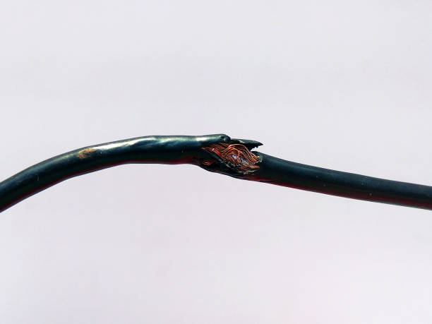 istock Damaged black electric cord on white background. Dangerous broken electrical cable 1135687890