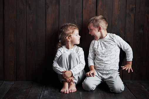 Two children, brother and sister in pajamas play together.