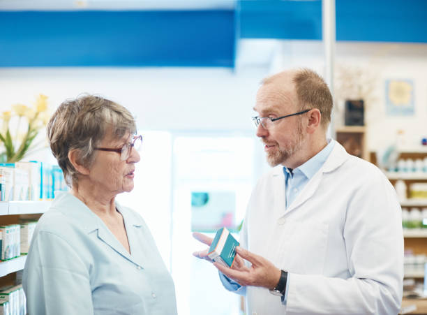 istock Male pharmacist explains medication to senior female customer 1135690057