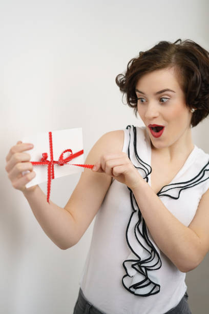 istock Excited young woman opening a gift 1135691136