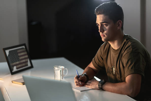 istock Young pensive American soldier taking notes at office desk. 1135691760