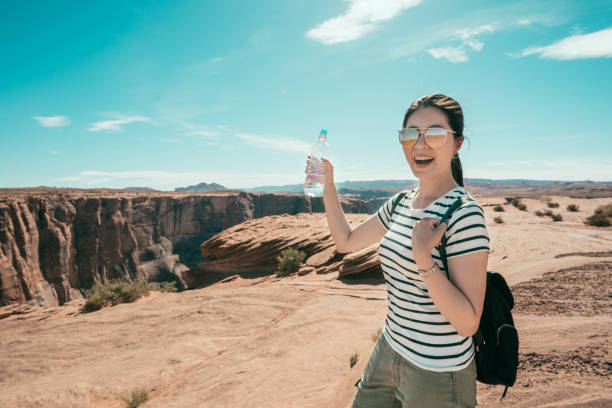 istock young hiker smiling raising up bottle 1135691944