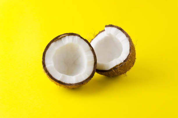 istock Cracked coconut on yellow background 1135695032