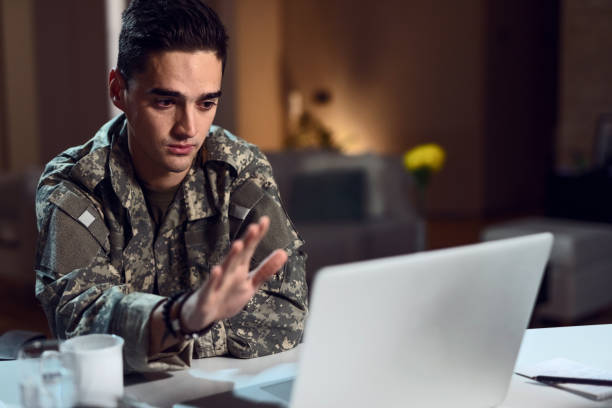 istock Young sad soldier waving while having video chat on laptop. 1135697091