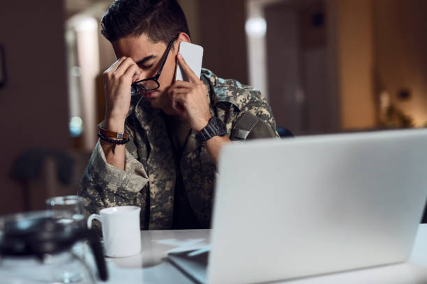 Upset military officer talking on the phone at his office.