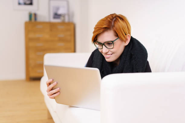 istock Pretty young woman relaxing with a tablet 1135698659